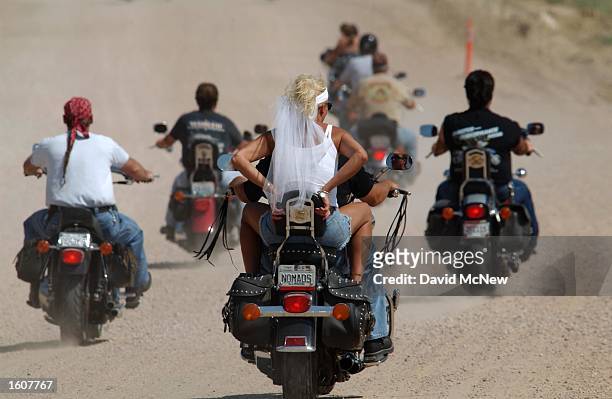 Woman wears a bridalveil while riding on a motorcycle near Hulett, WY, one of many destinations for cyclists attending the 61st annual Sturgis...