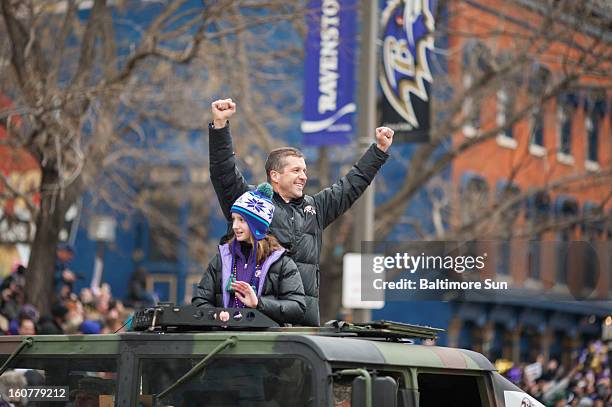 Baltimore Ravens head coach John Harbaugh and his daughter, Alison, wave to fans during a parade in Baltimore, Maryland, Tuesday, February 5, 2013.