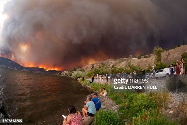 Residents watch the McDougall Creek wildfire in West Kelowna, British Columbia, Canada, on August 17 from Kelowna. Evacuation orders were put in...