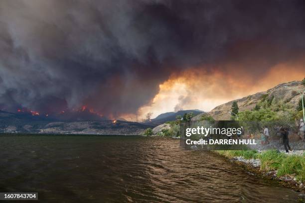 Residents watch the McDougall Creek wildfire in West Kelowna, British Columbia, Canada, on August 17 from Kelowna. Evacuation orders were put in...