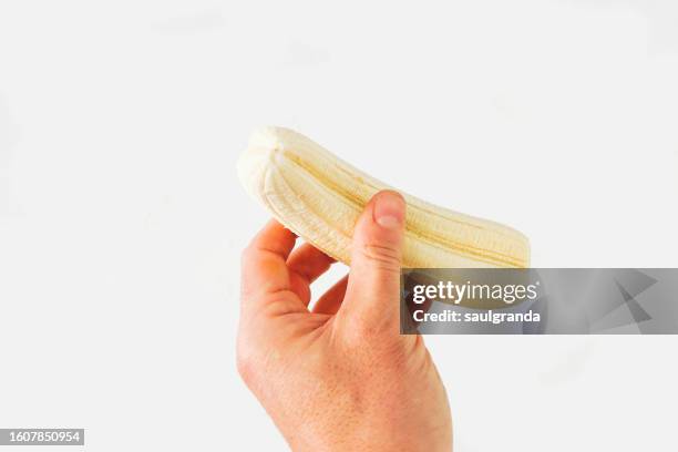 double canary islands banana in man's hand against white - comestibles stock pictures, royalty-free photos & images