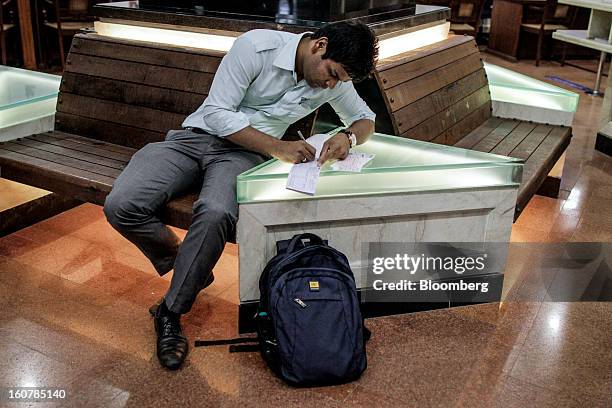 Customer writes on a cheque deposit slip at a HDFC Bank Ltd. Bank branch in Mumbai, India, on Friday, Feb. 1, 2013. HDFC Bank, India’s second-largest...