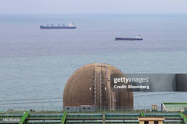 The No. 4 reactor building stands at Korea Hydro & Nuclear Power Co.'s Kori nuclear power plant as ships sail past in Busan, South Korea, on Tuesday,...