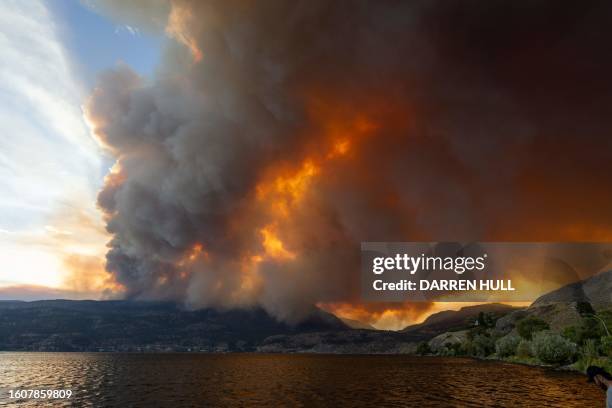 The McDougall Creek wildfire burns in the hills West Kelowna, British Columbia, Canada, on August 17 as seen from Kelowna. Evacuation orders were put...