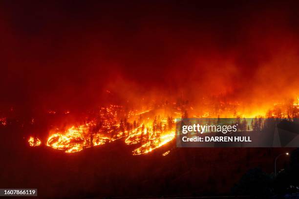 The McDougall Creek wildfire burns in the hills West Kelowna, British Columbia, Canada, on August 17 as seen from Kelowna. Evacuation orders were put...