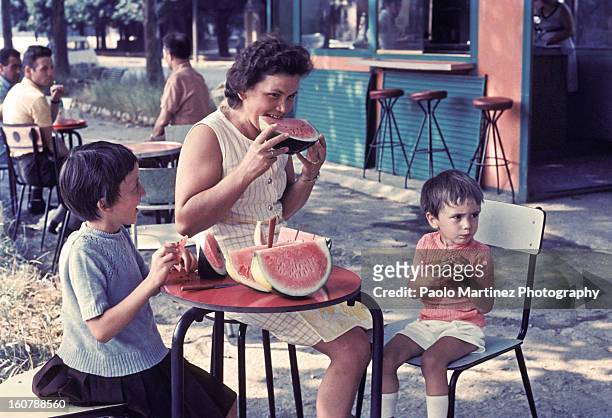 mother and two children eating watermelon outdoors - de archivo fotografías e imágenes de stock