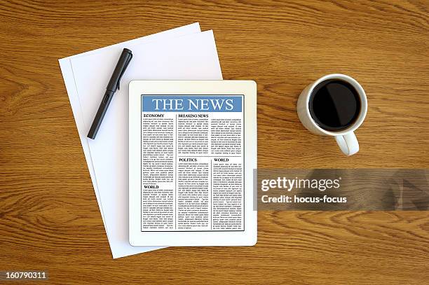 タブレット pc でニュース - newspaper on table ストックフォトと画像