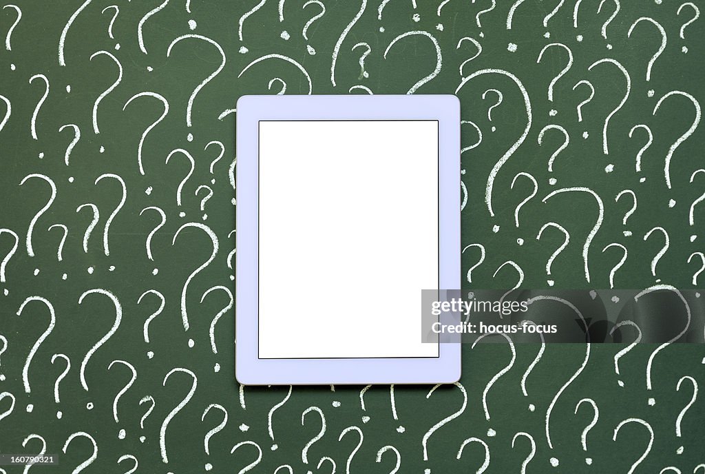 Tablet pc in front of question marks