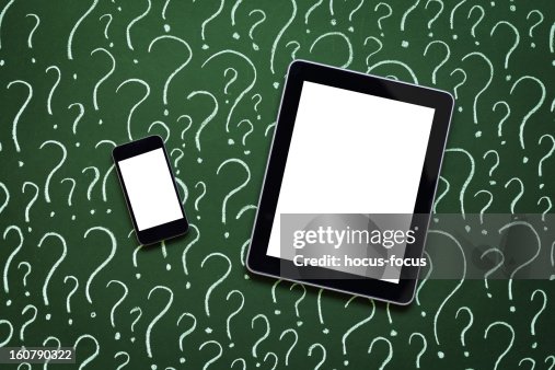 Tablet pc and smart phone in front of question marks Tablet pc and smart phone in front of question marks