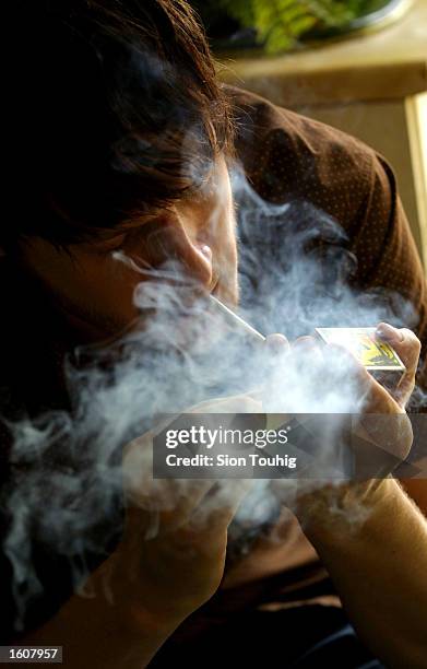 Man smokes marijuana at his home August 8, 2001 in the Dalston section of East London. Cannabis use in the United Kingdom is still illegal, but it''...