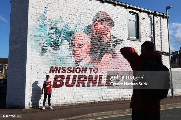 Young fan of Burnley poses for a photo next to a Burnley mural prior to the Premier League match between Burnley FC and Manchester City at Turf Moor...