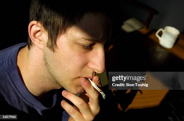 Man smokes marijuana at his home August 8, 2001 in the Dalston section of East London. Cannabis use in the United Kingdom is still illegal, but it''...