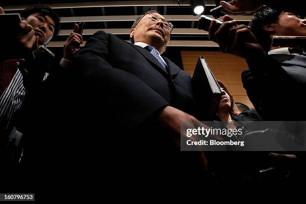 Takashi Yamanouchi, chief executive officer of Mazda Motor Corp., center, leaves after speaking to members of the media following a news conference...