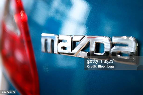 Signage for Mazda Motor Corp. Is displayed on a Demio compact vehicle at the company's showroom in Tokyo, Japan, on Wednesday, Feb. 6, 2013. Mazda,...