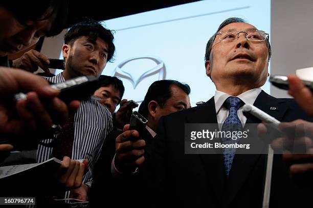 Takashi Yamanouchi, chief executive officer of Mazda Motor Corp., right, speaks to members of the media following a news conference in Tokyo, Japan,...