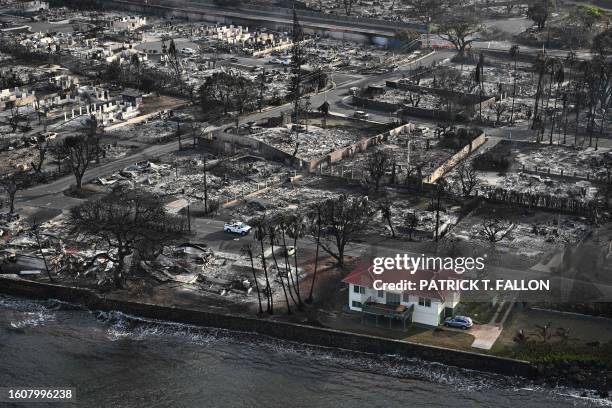 An aerial image shows a red roofed house that survived the fires surrounded by destroyed homes and buildings burned to the ground in the historic...