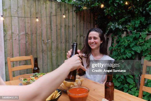 women cheering with beers at backyard party - chink santana stock pictures, royalty-free photos & images