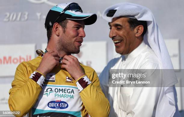 Mark Cavendish of Great Britain and Omega Pharma - Quick Step pulls on the race leaders gold jersey after winning stage four of the Tour of Qatar...