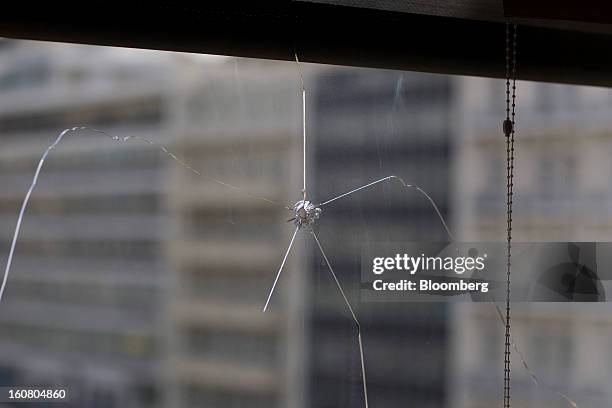 Bullet hole is seen in the office window of Yannis Stournaras, Greece's finance minister, following a Bloomberg Television interview in Athens,...