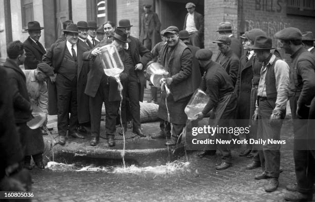 New York City Liquor Agent Izzy Einstein dumping liquor into gutter during prohibition.