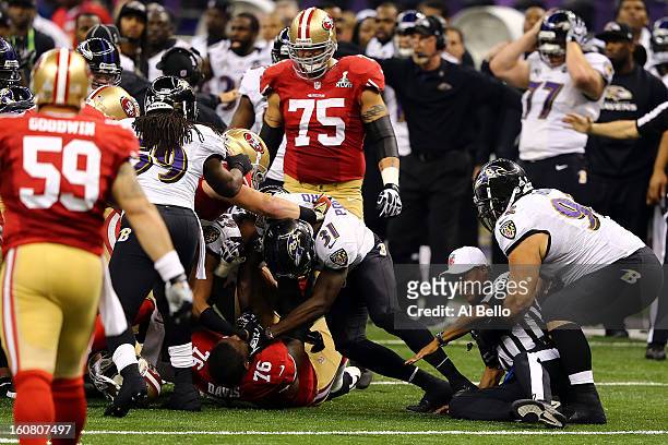 Bernard Pollard of the Baltimore Ravens holds down Anthony Davis of the San Francisco 49ers in a pile up of players as Haloti Ngata of the Ravens...