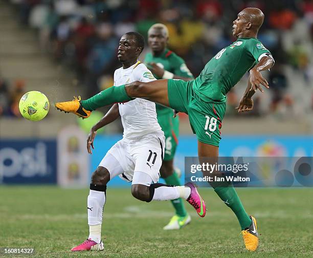Mohammed Rabiu Alhassan of Ghana is tackled by Kabore Charles of Burkina Faso during the 2013 Africa Cup of Nations Semi-Final match between Burkina...