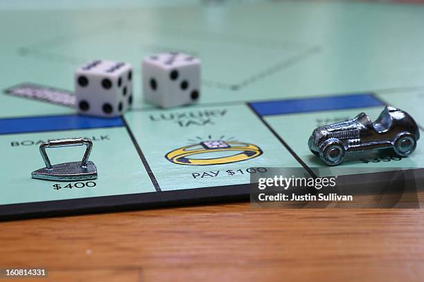 In this photo illustration, The Monopoly iron and race car game pieces are displayed on February 6, 2013 in Fairfax, California. Toy maker Hasbro,...