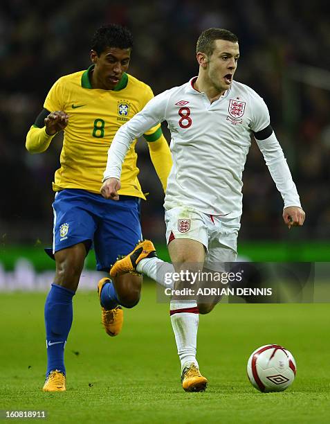 England's midfielder Jack Wilshere runs with the ball chased by Brazil's midfielder Paulinho during the international friendly football match between...