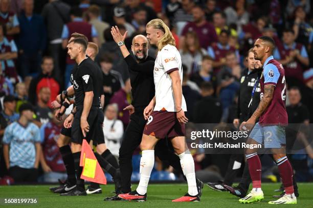 Josep Guardiola, Manager of Manchester City, speaks with Erling Haaland during the Premier League match between Burnley FC and Manchester City at...