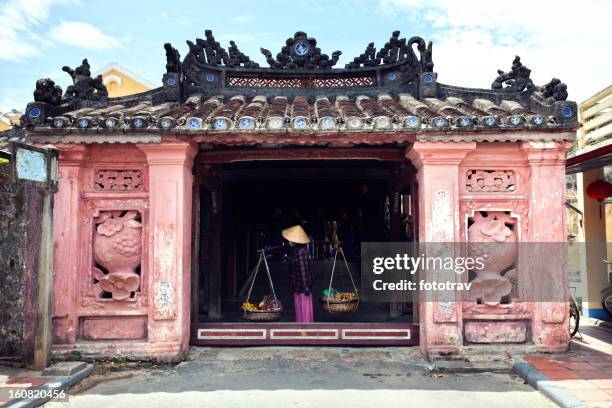 street vendor crossing the japanese bridge in hoi an, vietnam - hoi an vietnam stock pictures, royalty-free photos & images