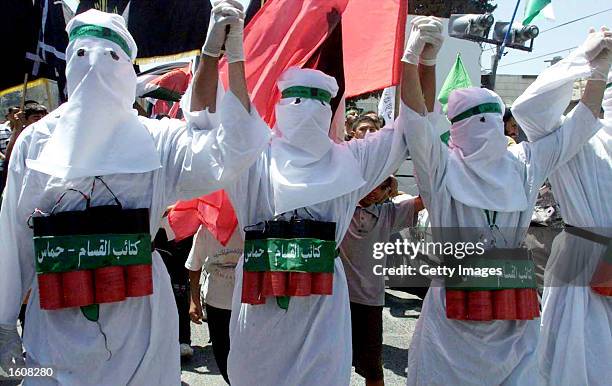 Masked Palestinian Hamas members dressed as suicide bombers march in a Hamas demonstration August 10, 2001 in the West Bank city of Jenin. Hundreds...