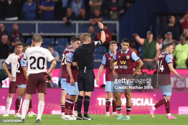 Referee Craig Pawson shows a red card to Anass Zaroury of Burnley during the Premier League match between Burnley FC and Manchester City at Turf Moor...