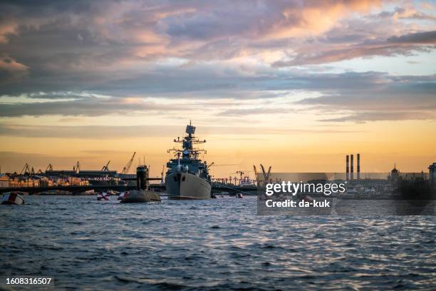 navire de guerre militaire naviguant sur la neva à saint-pétersbourg au coucher du soleil - warship neva photos et images de collection