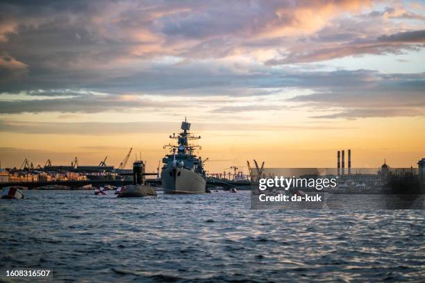 military warship sailing in neva river at st. petersburg at sunset - warship stock pictures, royalty-free photos & images