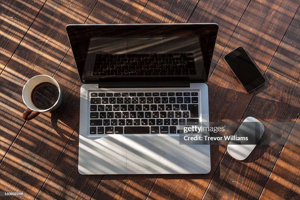 Open laptaop, with smartphone, mouse, and coffee