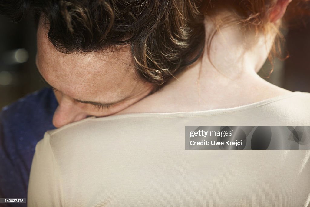 Man resting his head on woman's shoulder
