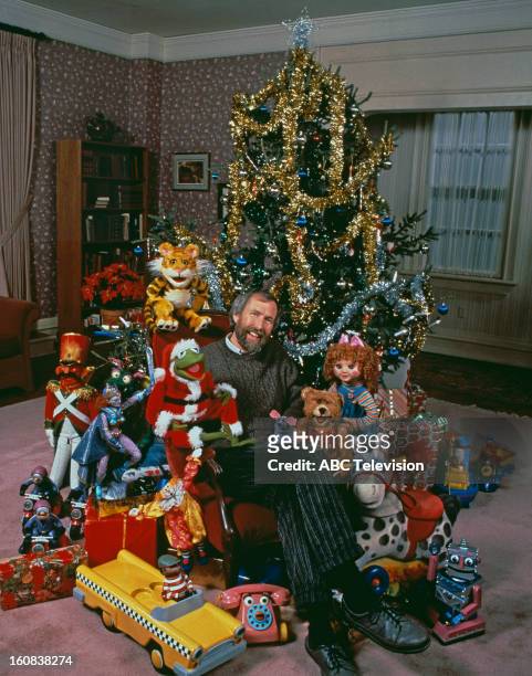 American puppeteer and filmmaker Jim Henson with muppet characters from the ABC TV movie 'The Christmas Toy', directed by Eric Till, 1986. Sitting...