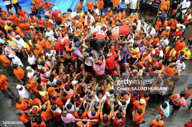 Indian devotees of Hindu God, Lord Krishna form a human pyramid as they prepare to break a 'dahi-handi' during a festival in Mumbai on August 14 as...