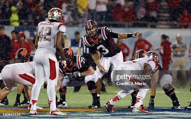 Quarterback Logan Thomas of the Virginia Tech Hokies directs the offense against the Rutgers Scarlet Knights during the Russell Athletic Bowl Game at...