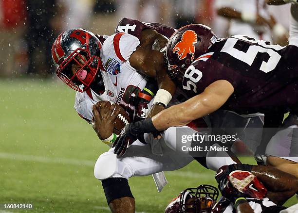 Running back Savon Huggins of the Rutgers Scarlet Knights is tackled by safety Detrick Bonner of the Virginia Tech Hokies during the Russell Athletic...