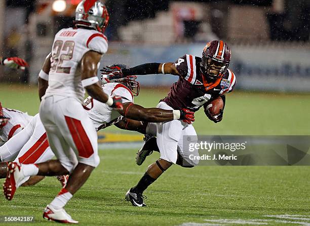 Running back J.C. Coleman of the Virginia Tech Hokies straight-arms defensive tackle Marvin Booker of the Rutgers Scarlet Knights during the Russell...