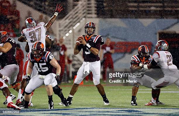 Quarterback Logan Thomas of the Virginia Tech Hokies looks for an open receiver against the Rutgers Scarlet Knights during the Russell Athletic Bowl...