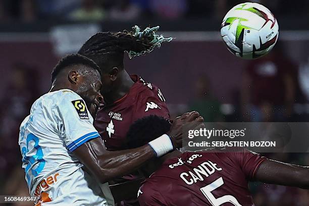 Marseille's Congolese defender Chancel Mbemba fights for the ball with Metz's French midfielder Kevin N'Doram and Metz's Guinea-Bissau defender Fali...