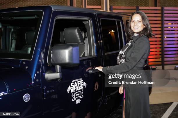 Actress Olivia Munn poses in front of the Jeep Wrangler Freedom Edition at the launch event for Jeep Operation Safe Return at the USO Warrior &...