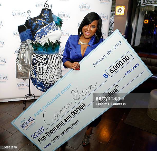 Designer Carmen Green of Baltimore, MD poses in front of her winning design with her prize check after winning The Aquafina "Pure Challenge" at the...