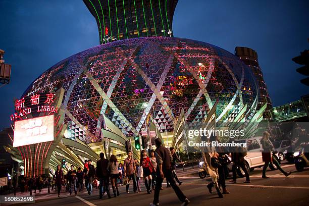 Pedestrians cross an intersection in front of the Casino Grand Lisboa, operated by SJM Holdings Ltd., in Macau, China, on Wednesday, Feb. 6, 2013....