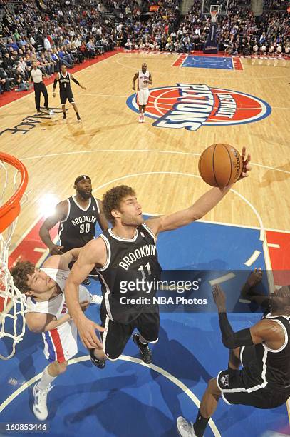 Brook Lopez of the Brooklyn Nets grabs a rebound against Viacheslav Kravtsov of the Detroit Pistons on February 6, 2013 at The Palace of Auburn Hills...