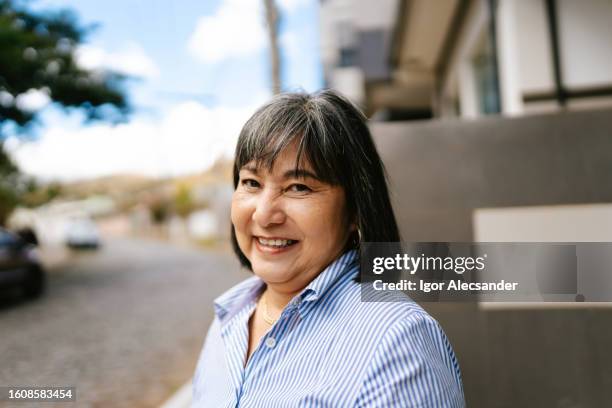portrait of a smiling woman in the city - straight hair stock pictures, royalty-free photos & images