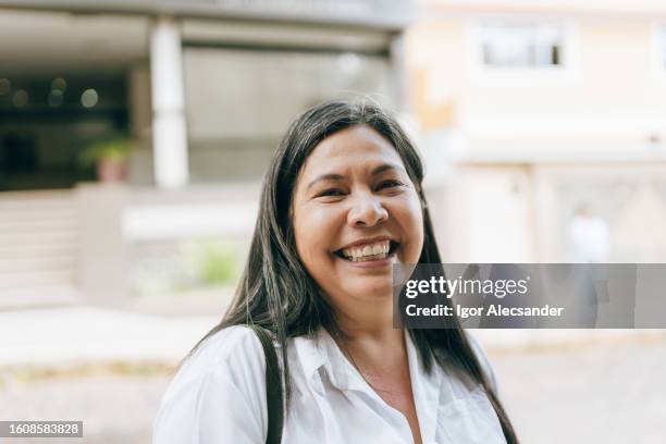 portrait d’une femme souriante et joyeuse dans la rue - real people lifestyle photos et images de collection