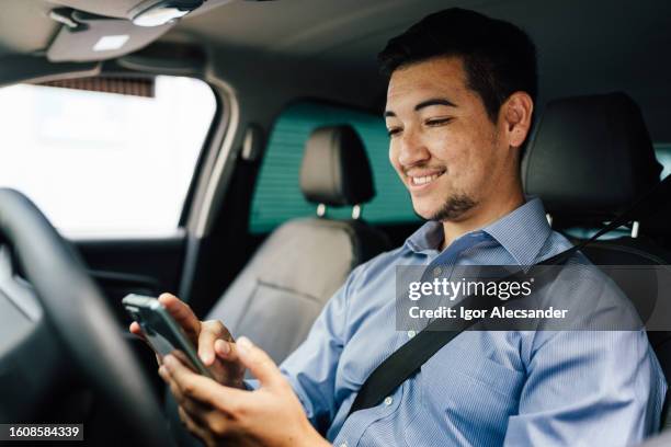 app driver using smartphone in car - travel real people stockfoto's en -beelden